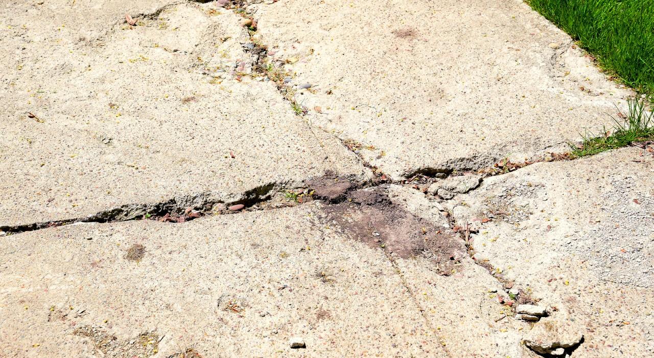 bigstock-Damaged-sidewalk-in-need-of-re-187835611